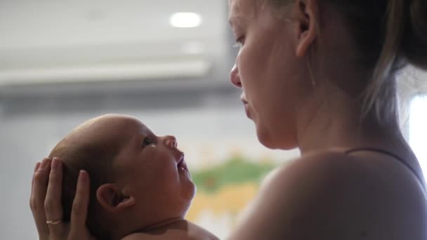 Young woman making faces to her newborn child — Stock Video