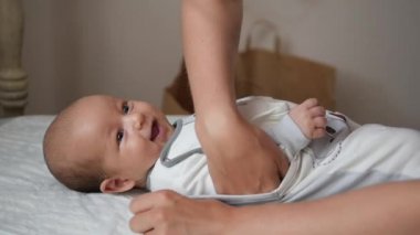 Bir romper giyinik mutlu gülümseyen bebek el atış.