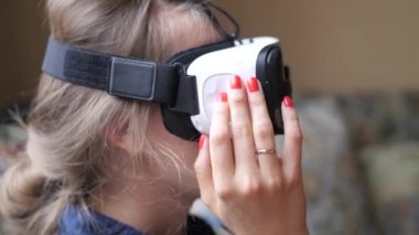 VR-kask evde kullanan genç kadın. El atış