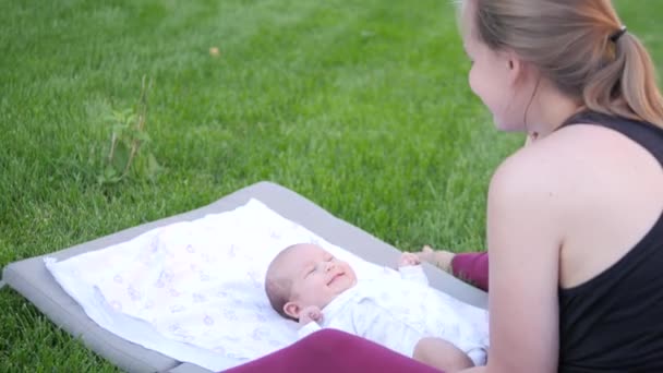 Mère faisant rire hir enfant. Repose-toi sur une pelouse. Coup de main — Video