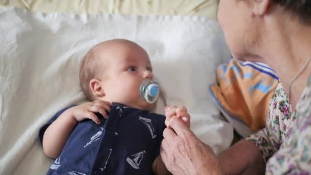 Aged granny playing and talking to the grandchild. Handheld shot — Stock Video