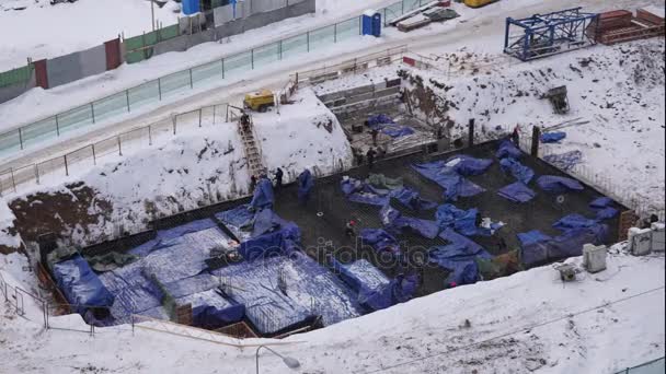 Dělníci na staveništi v zimě zasněžený den. Timelapse — Stock video