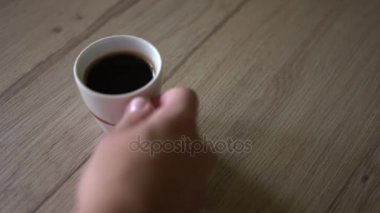 Adam siyah kahve bir fincan bir masanın üzerine koyar. Üstten Görünüm