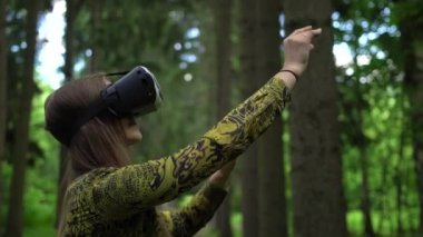 Kadın sanal nesneleri bir orman Vr headsetin ile oynarken yakalamaya çalışır