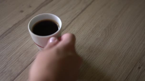 Man zet een kopje zwarte koffie op een tafel. Bovenaanzicht — Stockvideo