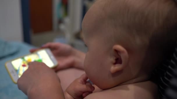 Adulto con smartphone mostra un video per il bambino piccolo. Colpo palmare — Video Stock