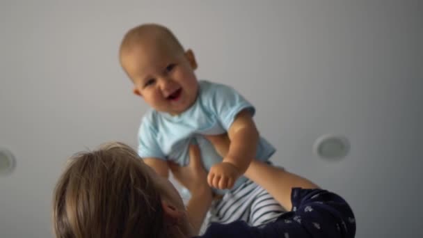 Kadın kaldırdı ve onun gülen bebek sallıyor. Düşük açısı Shot — Stok video