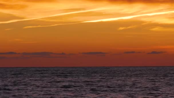Φωτεινό πορτοκαλί ηλιοβασίλεμα ουρανό πάνω κουνώντας την επιφάνεια της θάλασσας. Υπέροχη Θαλασσογραφία — Αρχείο Βίντεο