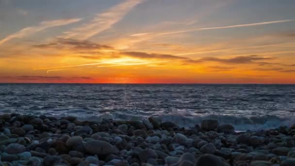 Timelapse do sol alaranjado brilhante que se põe no mar Negro. Pôr do sol em uma praia de calhau — Vídeo de Stock