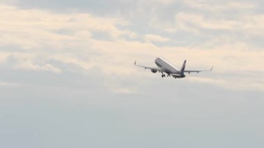 Yolcu uçak iniş takımı almak sonra kapalı geri çeker ve overcasted gökyüzünde uçar