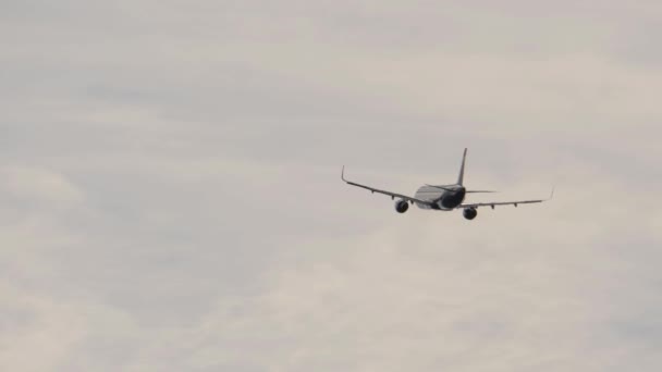Самолет набирает высоту в облачном небе после взлета — стоковое видео