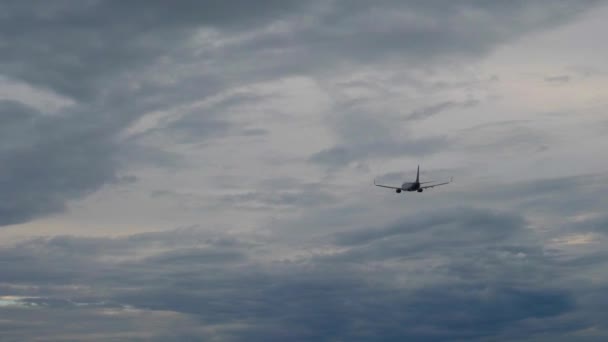 Silueta de avión de pasajeros volando en el cielo tormentoso — Vídeos de Stock