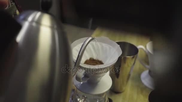 バリスタは点滴を醸造コーヒーを作るための挽いたコーヒーをフィルターに水を注ぐ — ストック動画