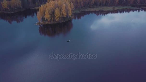 Kleines Motorboot schwimmt auf dem plätschernden blauen Wasser des Sees inmitten des Fallwaldes. Luftaufnahme — Stockvideo