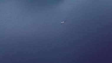 Mavi Göl su yüzey dalgalanan küçük Motorlu tekne yüzer. Hava Üstten Görünüm