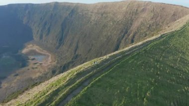 Kalderanın kenarına giden iki kişinin havası. Faial Adası yanardağı, Azores