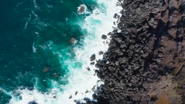 Luchtfoto van de oceaangolven die aanspoelen op een zwarte vulkanische rots van de Azoren. Bovenaanzicht — Stockvideo