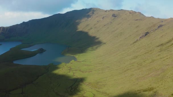 Światło słoneczne i cienie na zielonych stokach wulkanu Corvo. Zdjęcie lotnicze Caldirao caldera, Azory — Wideo stockowe