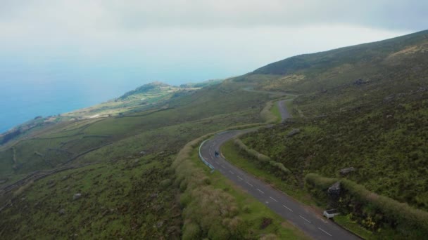 Um par caminha na estrada sinuosa nas montanhas. Aeronave do vulcão Caldeirao turvo, Corvo, Açores — Vídeo de Stock