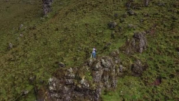 Young couple on the top of rock on the edge of caldera. Caldeirao volcano, Corvo, Azores — Stock Video