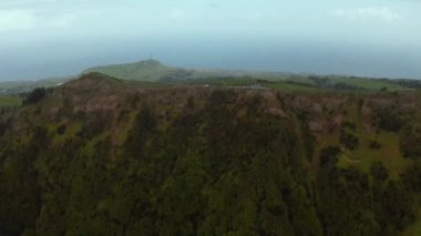 Tepesi yamacında orman, tepesinde yol. San Miguel adası, Azores 'in dağları.