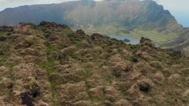 Flying into caldera of vast inactive volcano. Lake on the top of Caldeirao. Aerial of Corvo, Azores — Stock Video