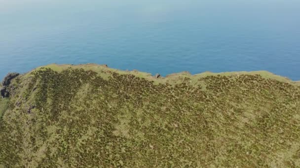 Um penhasco íngreme acima do oceano azul. Montanha em uma costa marítima. Aeronave do vulcão inactivo, Corvo, Açores — Vídeo de Stock