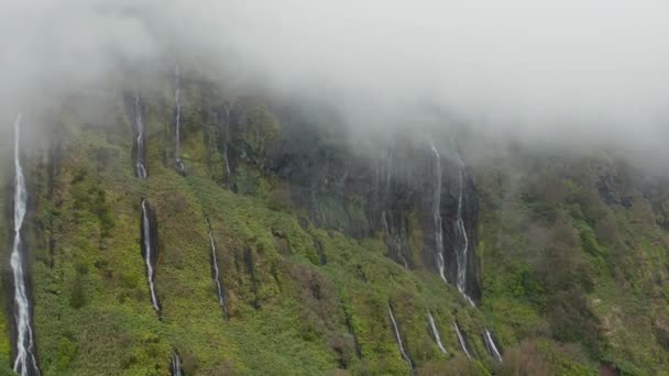Ferreiro cascade on steep cliff. Water falls from the top in clouds. Aerial of Flores island, Azores — Stock Video