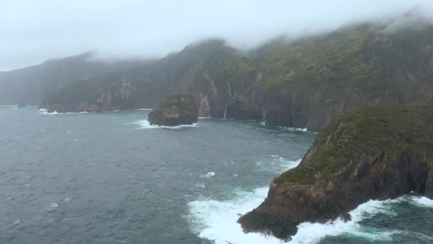 Neblige Küstenfelsen. Wasserfall fällt ins Meer. Wolken oben auf dem Berg. Antenne von San Miguel, Azoren — Stockvideo