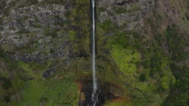 Bacalhau şelalesi deresi kayalık dağın tepesindeki bir vadiden düşüyor. Flores Havası, Azores