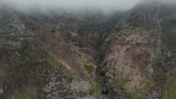 Cascade in rocky gorge disappears in cloud. Flying above mountains. Aerial of Flores, Azores — Stock Video