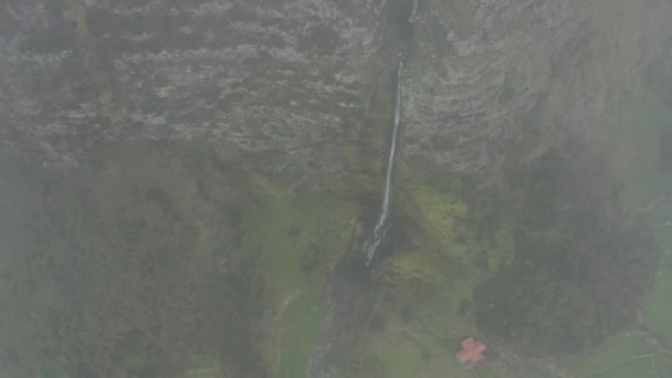 Vue de dessus de la cascade. Descendre du nuage au-dessus d'une falaise rocheuse. Vue Aérienne de Poco do Bacalhau, Flores, Açores 