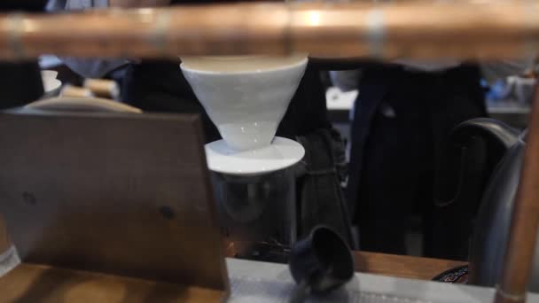 バリスタは、コーヒーを淹れ、コーヒーを飲みながらフィルターにお湯を注ぎます。代替コーヒー製造方法 — ストック動画