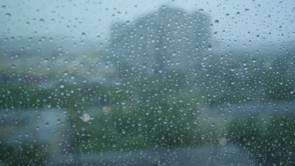 As gotas de chuva descem em um copo de janela. O mau tempo numa cidade. Fechar — Vídeo de Stock