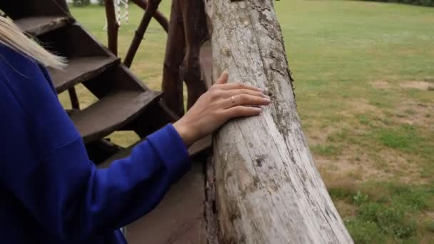 Femme monte dans les escaliers tenant sur un rail en tronc d'arbre sec — Video