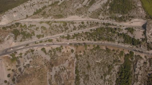 車はヘアピンターンで移動します。岩場の山の急な斜面に高速道路。クロアチア — ストック動画