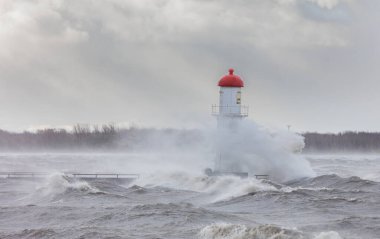 Fırtınalı dalgalarla kaplı dramatik deniz feneri görüntüsü