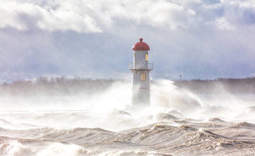 dramatic shot of lighthouse covered with stormy waves