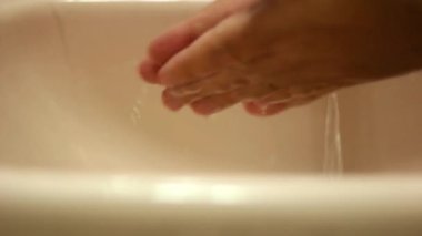 Prevention of the coronavirus pandemic: wash hands with warm water and soap. Washing hands with soap and hot water at home sink. A man cleans hands to prevent an outbreak of coronavirus