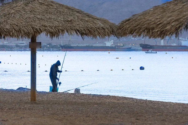 Homme pêchant à la mer Rouge, sur la plage d'Eilat, Israël — Photo