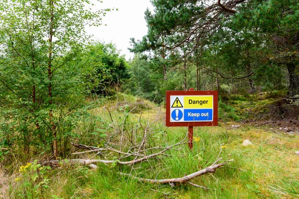 Лесной знак с надписью "Опасность! Держитесь подальше !" — стоковое фото
