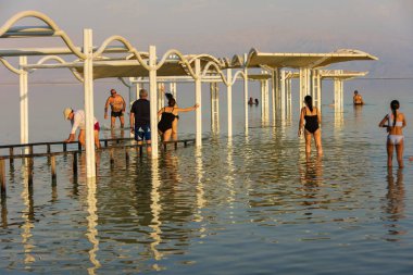 ÖLÜ SEA, ISRAEL - 13, 2019: insanlar akşam saatlerinde Ölü Deniz 'in ılık sularında yüzüyor, yüzüyor ve DJ' lik yapıyor.