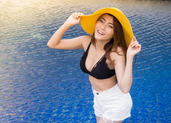 Porträtt av asiatisk kvinna i svart bikini top och denim skott. — Stockfoto