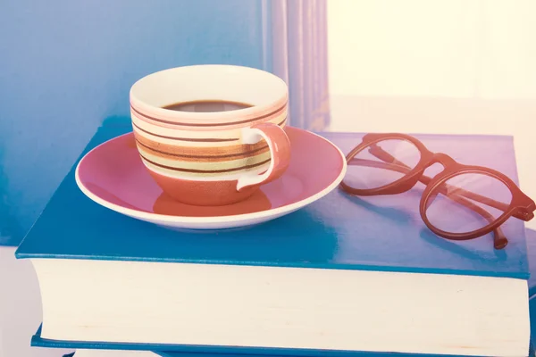 Cup of coffee on stack book with Eyeglasses for background — Stock Photo, Image