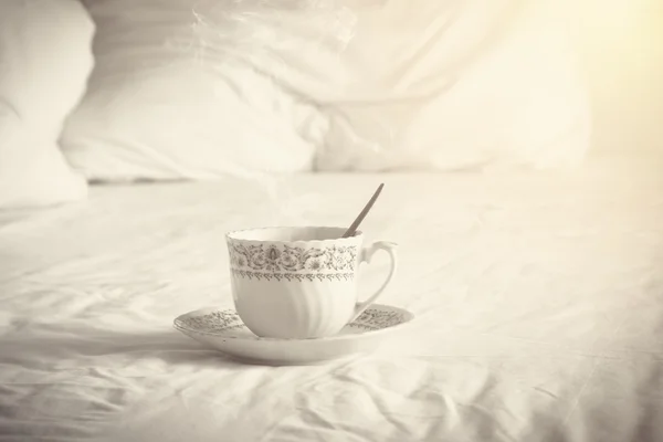 Coffee cup on sofa with pillows in morning — Stock Photo, Image