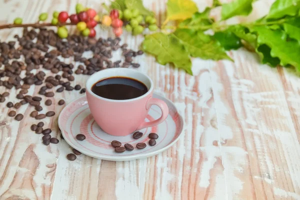 Ceașcă de cafea fierbinte neagră cu fasole și cireș.pe masă de lemn — Fotografie, imagine de stoc