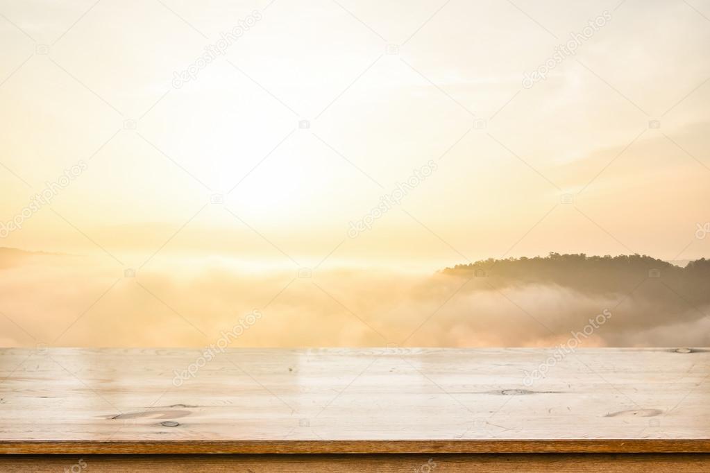 Empty top wooden table over sea of mist blurred mountain background. For display your product