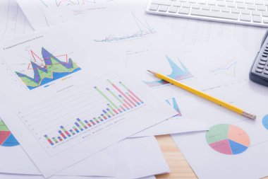 Belgeler Ofis masasında hesap makinesiyle grafikleri analiz