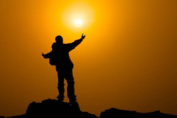 Homem com braços estendidos para o céu ao nascer do sol, sucesso ou conceito de oração — Fotografia de Stock