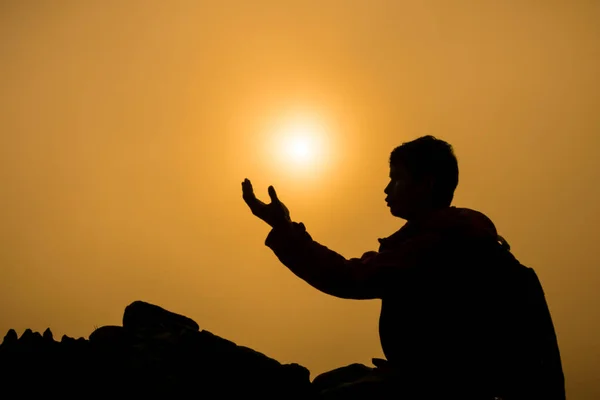 折り敷きと美しい日の出背景を祈る男のシルエット — ストック写真